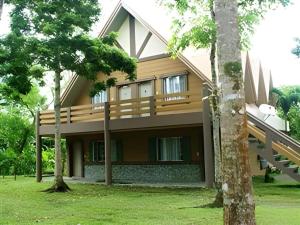 a house with a balcony and trees at Pineapple Island Resort in Badas