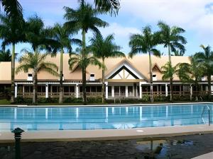a resort with a swimming pool and palm trees at Pineapple Island Resort in Badas