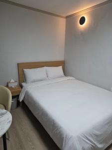 a bedroom with a large white bed and a table at 고요스테이 in Chuncheon