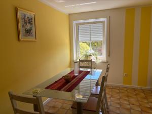 a dining room with a glass table and a window at Ferienwohnung Fuchs in Roding