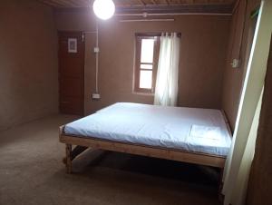 a bedroom with a bed in a room with a window at DnD cottages in Mandi +16 photos