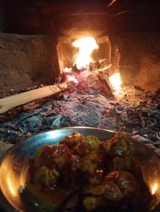 a plate of food in front of a brick oven at DnD cottages in Mandi