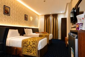 a hotel room with two beds and a television at Maysan Al Safa Hotel in Mecca