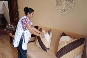 a woman standing next to a bed with pillows at Shalom in Colva