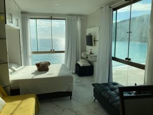 a bedroom with a teddy bear sitting on a bed at Loft da Prainha in Arraial do Cabo