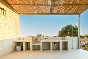 an outdoor kitchen in a patio with a wooden ceiling at Sky And Stone Private Villa in Kathiana