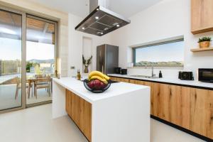 a kitchen with a bowl of fruit on a counter at Sky And Stone Private Villa in Kathiana