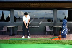 a man is playing golf on a putting green at Calista Cruise - A Ha Long Bay Spectacle in Ha Long
