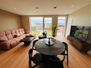 a living room with a couch and a table and a tv at Arctic Privé Panorama Residence Alta in Alta
