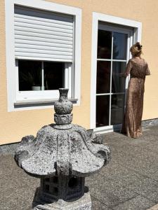 a woman in a dress standing outside of a building at Ferienwohnung Fuchs in Roding +3 photos