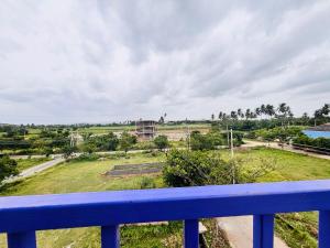 a view of a field from a balcony at Hampi Icon Palace in New Hampi
