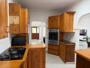 a kitchen with wooden cabinets and a stove top oven at 2 bedrooms Ngubelanga Stays in Margate