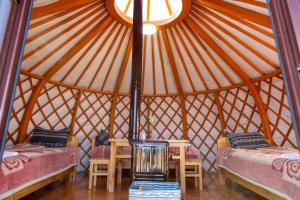 a room with two beds and a table in a yurt at Maikhan Tolgoi lodge in Horgo