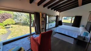 a bedroom with a bed and a large window at Hotel Jardín de Aura in Muros de Nalón +17 photos