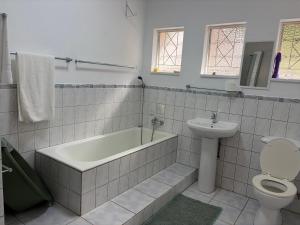a bathroom with a tub and a toilet and a sink at 2 bedrooms Ngubelanga Stays in Margate +22 photos