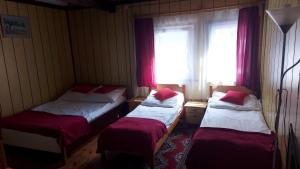 two twin beds in a room with a window at Nad Bałtykiem in Mrzeżyno