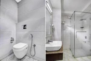 a bathroom with a shower and a toilet and a sink at Saffron by Stay Pattern - City Center in Srinagar