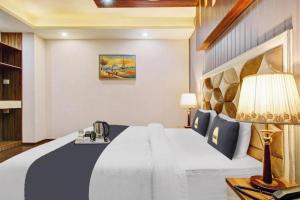 a bedroom with a large bed and a lamp at Saffron by Stay Pattern - City Center in Srinagar