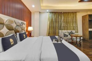 a hotel room with a large bed and a chair at Saffron by Stay Pattern - City Center in Srinagar