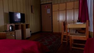 a bedroom with a tv and a desk and a table at Nad Bałtykiem in Mrzeżyno