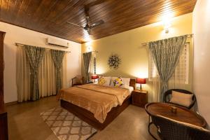 a bedroom with a bed and a table and chairs at The Elegant homes in Kushālnagar +57 photos
