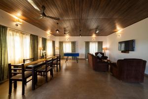 a living room with a long table and chairs at The Elegant homes in Kushālnagar