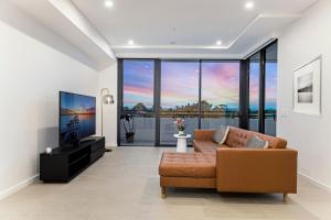a living room with a couch and a flat screen tv at Modern 2BR Free parking near Olympic park in Sydney