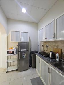 a kitchen with a stainless steel refrigerator and a sink at Towaya studio in Al Ain