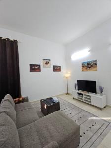 a living room with a couch and a flat screen tv at Towaya studio in Al Ain