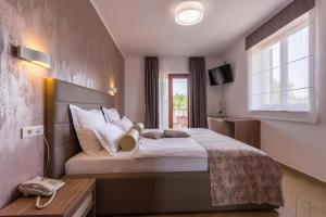 a bedroom with a large bed and a window at B&B Vila Milčetić in Malinska