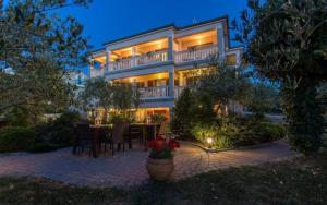 a large building with a table in front of it at B&B Vila Milčetić in Malinska