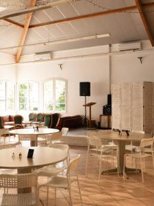 a room with tables and chairs and a couch at Chambres de la Bastide des Joncas in Martigues