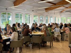 a group of people sitting at tables in a restaurant at Chambres de la Bastide des Joncas in Martigues