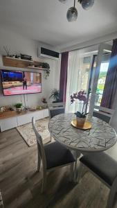 a dining room with a table and chairs and a tv at Divine Luxury Rasnov in Râşnov