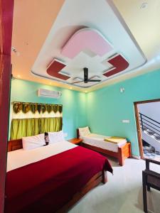 a bedroom with two beds and a ceiling fan at Hampi Icon Palace in New Hampi