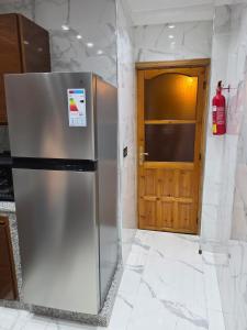 a stainless steel refrigerator in a kitchen with a door at Dar AWRABIA in Fez