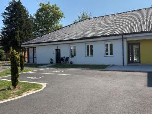 a white building with a parking lot in front of it at PlatanHome 12 in Lenti