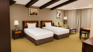 a hotel room with two beds and a desk at Desert Inn Resort and Camp in Ras al Khaimah +158 photos