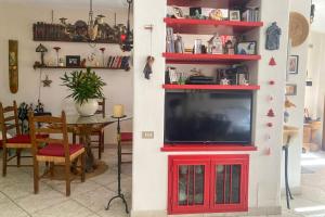 a living room with a television in a red entertainment center at Guesthouse Nuvole in Olbia