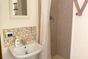 a bathroom with a sink and a shower at Guesthouse Nuvole in Olbia +15 photos