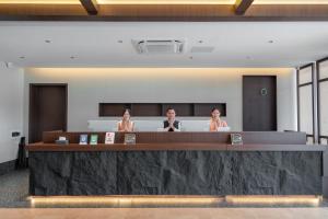 three women sitting at a counter in a hotel lobby at Vangvieng THAVIKUN HOTEL in Vang Vieng +75 photos