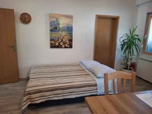 a bedroom with a bed and a clock on the wall at Apartma Jasen in Ilirska Bistrica