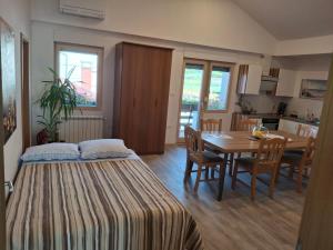 a room with two beds and a table and a dining room at Apartma Jasen in Ilirska Bistrica