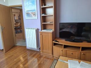 a living room with a flat screen tv and a table at Apartma Jasen in Ilirska Bistrica