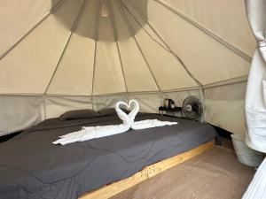a white swan on a bed in a tent at Heaven Khaokho (เฮฟเว่น) in Khao Kho