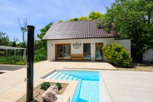 a house with a swimming pool in front of a building at Penzión Walter in Veľké Úľany