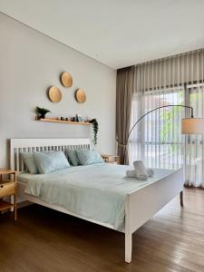 a white bedroom with a white bed and a window at Lioravilla21 Kota Baru Parahyangan in Padalarang +27 photos