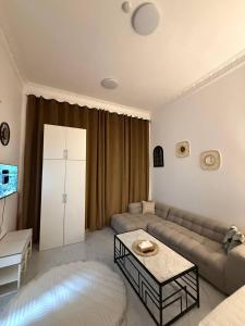 a living room with a couch and a table at Lightmoon studio Jimi in Al Ain