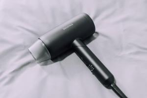 a hair dryer sitting on top of a bed at Work Ready Stay - Quiet Nakasu 202 in Fukuoka