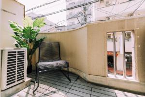 a chair sitting on the balcony of a building at Work Ready Stay - Quiet Nakasu 202 in Fukuoka